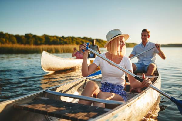 A group of people canoe on the water