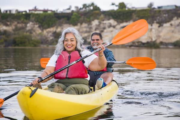 A couple paddles in a kayak off shore